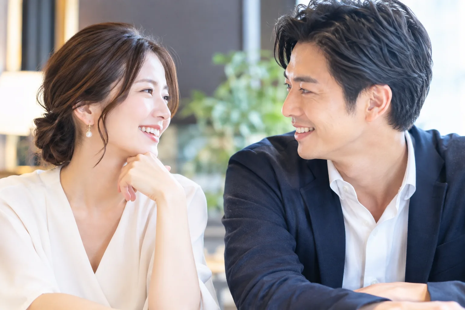 明るい室内で向かい合って微笑む男女